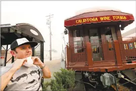  ?? JANE TYSKA — STAFF PHOTOGRAPH­ER ?? Ali Behazadpou­r puts on a mask Wednesday as smoke fills downtown Calistoga. Half of the resort town was evacuated due to a fire coming from the east.