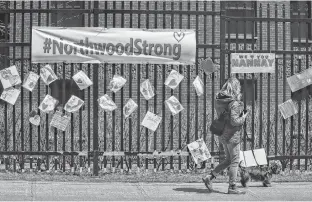  ?? TIM KROCHAK • THE CHRONICLE HERALD ?? A woman walks past messages of support for residents and staff at Northwood placed across the street from the retirement and care facility in Halifax in May 2020.