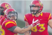  ?? Ted Rhodes/calgary Herald ?? University of Calgary receiver Brendan Thera, right, celebrates his first-quarter touchdown against the Manitoba Bisons with Dinos running back Bryce Harper on Friday at McMahon Stadium.