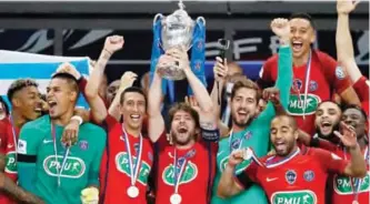  ?? ?? PARIS: Paris Saint-Germain’s Brazilian defender Maxwell (C) holds the trophy as he celebrates winning the French Cup final football match between Paris Saint-Germain (PSG) and Angers (SCO) on Saturday at the Stade de France in Saint-Denis, north of Paris. — AFP