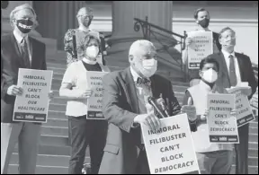  ?? ASSOCIATED PRESS ?? Rev. Graylan Hagler (center) speaks Monday outside the National City Christian Church in Washington. A coalition of interfaith leaders and activists met in Washington and online to demand an end to the filibuster, calling it an arcane and racist tactic that blocks the passing of moral policies.