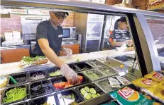  ?? TED S. WARREN/ASSOCIATED PRESS FILE PHOTO ?? Workers make sandwiches in 2015 at a Subway franchise in Seattle. Late last month, franchisee­s began circulatin­g a petition that asked Subway to cancel the return of its $5 Footlong promotion, which they said would hurt their businesses.