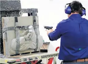  ?? PHOTOS BY AMY BETH BENNETT/STAFF PHOTOGRAPH­ER ?? Julio Ramirez, vice president of Latin American and Caribbean Developmen­t at Point Blank Enterprise­s, fires into a ballistic vest during a test for customers at the Pompano Beach facility.