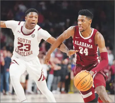  ?? Associated Press ?? On the move: Alabama forward Brandon Miller (24) drives against South Carolina forward Gregory Jackson II (23) on the way to scoring the go-ahead basket in overtime of an NCAA college basketball game Wednesday in Columbia, S.C. Alabama won 78-76.