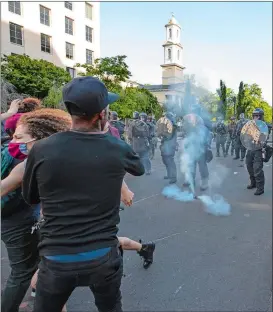  ?? ALEX BRANDON AP PHOTO ?? Arlington County Police, with St. John’s Episcopal Church behind them, use gas to move demonstrat­ors back, Monday in Washington.