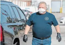  ?? FRANK GUNN THE CANADIAN PRESS ?? Premier Doug Ford picks up a load of masks made by The Woodbridge Group in Woodbridge, Ont. on Tuesday.