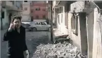  ?? AFP/ GETTY IMAGES ?? A Youtube image shows a Syrian man speaking outside the makeshift media centre where Sunday Times war correspond­ent Marie Colvin ( left, below) and French photojourn­alist Remi Ochlik ( right) died as they were targeted while trying to flee the building...