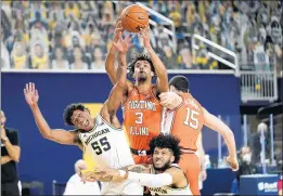  ?? PHOTOS BY PAUL SANCYA/AP ?? Illinois guard Jacob Grandison (3) pulls down a rebound over Michigan guard Eli Brooks (55) and Isaiah Livers.