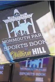  ?? SETH WENIG/ASSOCIATED PRESS ?? Signs for Monmouth Park are displayed in a bar at the racetrack in Oceanport, N.J. New Jersey is expected to be one of the first states to take advantage of the Supreme Court’s ruling Monday on sports betting.