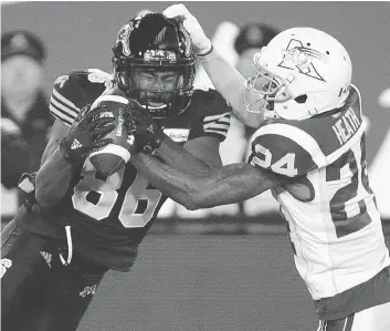  ?? PETER POWER / THE CANADIAN PRESS FILES ?? Tiger-cats wide receiver Bralon Addison is hit by Alouettes defensive back T. J. Heath in their Nov. 3 match-up. Addison racked up 124 yards in the Ticats’ East semifinal win Sunday over the B.C. Lions.