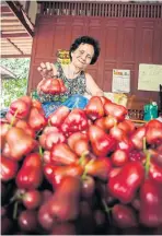  ??  ?? A farmer with her rose apples.