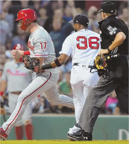  ?? STAFF PHOTO BY CHRISTOPHE­R EVANS ?? NOT SO FAST: Rhys Hoskins (left) is tagged out by Eduardo Nunez at third base during the third inning of last night’s game between the Red Sox and Philadelph­ia Phillies at Fenway Park.