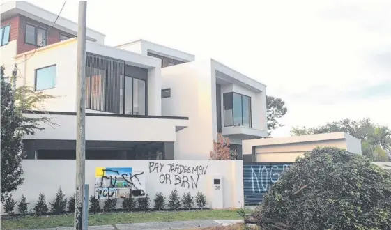  ??  ?? Crude graffiti sprayed on the side of a Broadbeach Waters house which had previously been under constructi­on by collapsed building firm AB Hill Constructi­ons.
