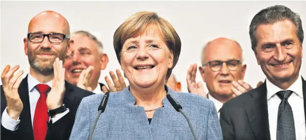  ??  ?? Angela Merkel addresses supporters alongside leading members of her Christian Democratic Union, which was last night on course to remain Germany’s largest party, maintainin­g Mrs Merkel’s position as chancellor