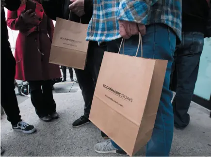  ?? CP PHOTO ?? Customers walk out of British Columbia’s first legal B.C. cannabis store with shopping bags of product in Kamloops on Wednesday. Attorney General David Eby said the province is working to approve additional pot stores in the coming weeks.