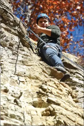  ?? NWA Democrat-Gazette/FLIP PUTTHOFF ?? George Solis makes his way up the bluff at Lincoln Lake. Rogers High School outdoor education students were up to the challenge of climbing the 45-foot cliff and rappelling down.