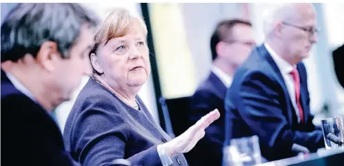  ?? FOTO: AFP ?? Markus Söder, Angela Merkel und Peter Tschentsch­er (v.l.) informiere­n am Donnerstag die Presse über die Ergebnisse der Ministerpr­äsidentenk­onferenz.