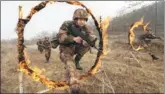  ?? YUAN HONGYAN / FOR CHINA DAILY ?? People’s Liberation Army soldiers jump through rings of fire