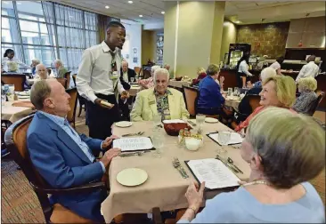  ?? HYOSUB SHIN / HSHIN@AJC.COM PHOTOS ?? Vacom Sambola takes food orders from Lenbrook residents (clockwise from left) Reid Hunter, Harold Ramos, Barbara Ramos and Martha Hunter at The Grill in Lenbrook Senior Community in Buckhead. With multiple distinctly different dining venues, Lenbrook is at the leading edge of a wave of change coming to senior living communitie­s.