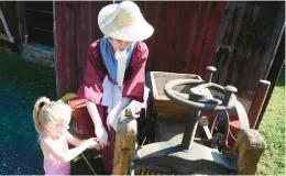  ?? AMY SHORTELL/THE MORNING CALL ?? Emma Roseman of Coopersbur­g learns how to use an apple press to make cider from Sabrina Moody during Apple Days in 2021 at Burnside Plantation.