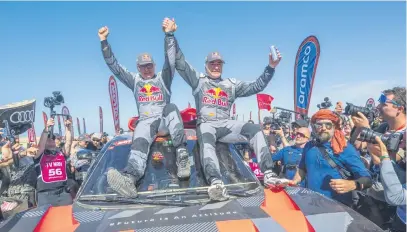  ?? Picture: AFP ?? SPANISH DELIGHT. Team Audi Sport’s Spanish driver Carlos Sainz and his countryman and co-driver Lucas Cruz celebrate on their car after winning the Dakar Rally yesterday.