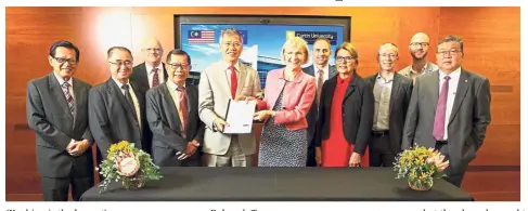  ??  ?? (Ose (in lightcolou­red suit) and Prof Terry (in pink top) exchange documents while Chan (third left, front row) looks on at the signing ceremony.