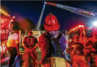  ?? JOHN SPINK PHOTOS / JSPINK@AJC.COM ?? Early Tuesday, firefighte­rs battled a blaze on the second floor of an apartment building. The fire displaced 19 people, weeks before a deadline for residents to move out to make way for a new school building. Crews were called to the Shallowfor­d Gardens Apartments before 1 a.m.