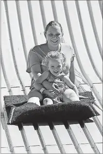  ?? [JOSHUA A. BICKEL PHOTOS/ DISPATCH] ?? Alexis Atkinson, top, of Columbus, slides down the Giant Slide with her daughter, Isabella Parsley, 3.