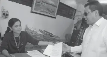  ?? KRISTINE JOYCE W. CAMPAÑA ?? Atty. Inocencio dela Cerna submits his motion to withdraw as legal counsel to Senior Superinten­dent Romualdo Iglesia and Senior Inspector Joselito Lerion, two of three police officials the Lapu-Lapu City Prosecutor’s Office have indicted over the death of lawyer Noel Archival and two others last February.