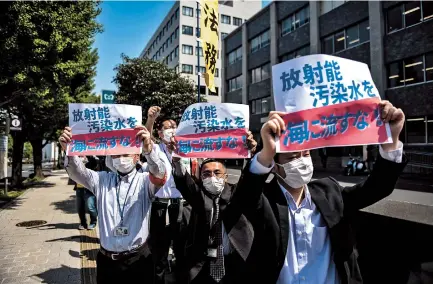  ??  ?? Activists take part in a protest against the Japan government’s plan to release treated water from the stricken Fukushima nuclear plant into the sea, outside the prime minister’s office in Tokyo yesterday. — AFP