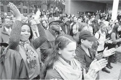  ?? AMY DAVIS/BALTIMORE SUN ?? Alexandra Waller, center, and Destiny Collins, arms raised, are among the students gathered at Towson University’s Freedom Square to voice their opinions about President-elect Donald Trump and to call for a greater emphasis on social justice and tolerance.