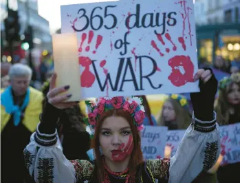  ?? KIN CHEUNG/AP ?? A Ukraine supporter holds a placard marking the first anniversar­y of the war during a protest Friday in London.