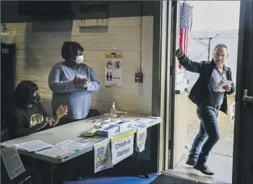  ?? Robert Gauthier Los Angeles Times ?? POLL WORKERS applaud Timoteo Antonio Ramirez after he joined those braving the rain on Tuesday to cast their ballots at Ted Watkins Memorial Park in South Los Angeles.