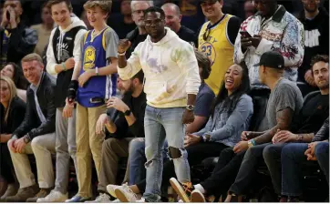  ?? ANDA CHU — STAFF ARCHIVES ?? Comedian and actor Kevin Hart, center, celebrates as the Golden State Warriors take on the Philadelph­ia 76ers at Chase Center in San Francisco on March 7. The NBA was forced to shut down because of Rudy Gobert’s positive coronaviru­s test.