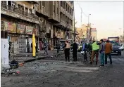  ?? ALI ABDUL HASSAN / AP ?? Iraqi security forces gather Monday at the scene of a double suicide bombing in Baghdad. The bombers, believed affiliated with the Islamic State, targeted Tayran Square during the morning rush hour.