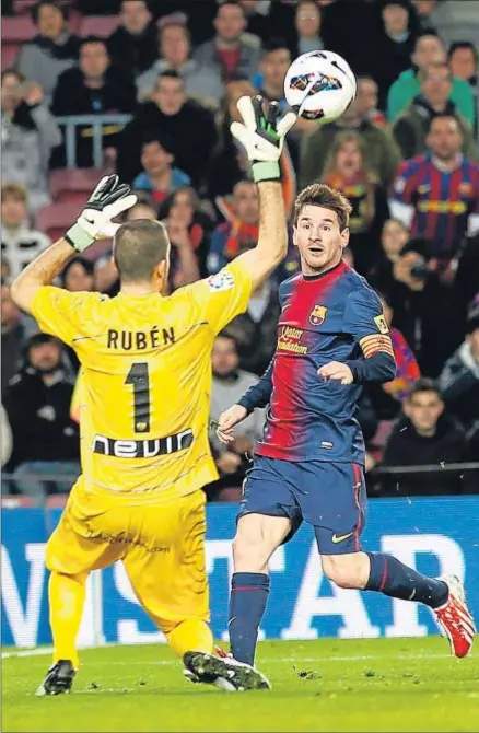  ?? GUSTAU NACARINO / REUTERS ?? Messi pone de forma exquisita el balón por encima del portero del Rayo