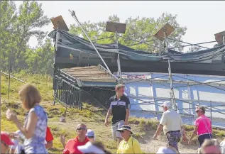  ??  ?? A leader board on a hill near the second hole is blown over after Friday's storms. Fans walked around the site during Round 3 of the PGA Championsh­ip at Whistling Straits in Haven.