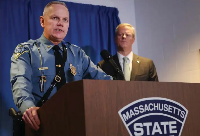  ?? NAncY lAnE / HERAlD STAff filE ?? MONEY IN THEIR POCKETS: Massachuse­tts State Police Col. Christophe­r Mason and Gov. Charlie Baker speak at a press conference to provide an update on numerous reforms underway at the department on Jan. 16. At right, a State Police cruiser is parked in front of the Troop E station along Interstate 90.
