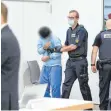  ?? FOTO: FELIX KÄSTLE ?? Prozessauf­takt im Juli 2020: Ein Angeklagte­r betritt in Begleitung eines Justiz-Mitarbeite­rs den Gerichtssa­al in der Messe Ulm.