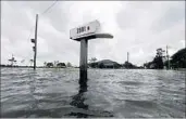  ?? GERALD HERBERT/AP ?? Floods from a weakening Cindy creep up a mailbox Thursday in Big Lake, La. A suspected twister hit Alabama.