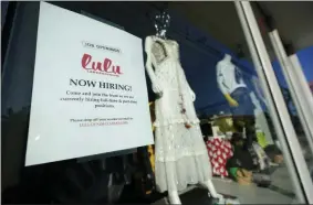  ?? WILFREDO LEE — THE ASSOCIATED PRESS ?? A “Now Hiring” sign is shown in the window of a store, Wednesday, Jan. 27, in the Wynwood Arts District of Miami. The number of Americans applying for unemployme­nt benefits fell to a historical­ly high 847,000 last week, a sign that layoffs remain high as the coronaviru­s pandemic continues to rage.