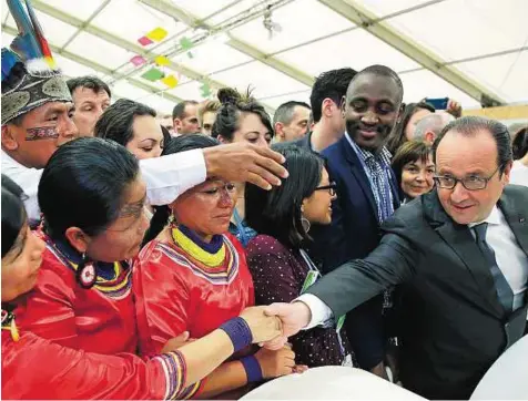  ?? AP ?? Reaching out French President Francois Hollande greets Ecuadorian­s during the COP21, the United Nations Climate Change Conference, in Le Bourget, north of Paris yesterday.