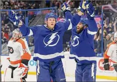  ?? Mike Carlson / Getty Images ?? Corey Perry, center, of the Lightning celebrates his goal with Pat Maroon as goalie Carter Hart (79) of the Flyers reacts.