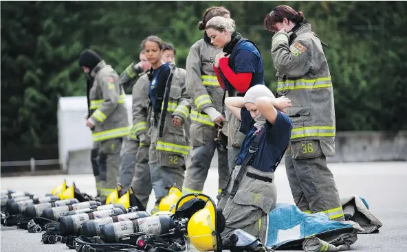  ?? RAFAL GERSZAK ?? Camp Ignite participan­ts put on their gear before entering a burning building at the Justice Institute in Maple Ridge Sunday.