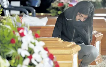  ?? ANDREAS SOLARO/GETTY IMAGES ?? A woman kneels next to the coffin of a relative in Amatrice, Italy, on Tuesday, prior to a funeral ceremony for the victims of last week’s earthquake, which killed 292 people.