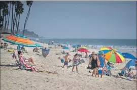  ?? Allen J. Schaben Los Angeles Times ?? BEACHGOERS ENJOY a sunny Wednesday in San Clemente. Orange and L.A. counties have not barred sunbathing this weekend, but Santa Barbara County has.