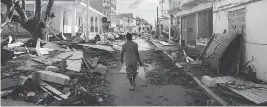  ?? MARTIN BUREAU/AFP/GETTY IMAGES ?? A man walks on a street covered in debris after Hurricane Irma caused extensive damage on French island of St. Martin, near Marigot, on Friday.