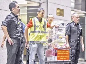  ?? GambarBern­ama ?? ANGGOTA polis memungah barang rampasan ke dalam trak polis di lobi sebuah kondominiu­m mewah, dipercayai berkaitan dengan bekas perdana menteri, Datuk Seri Najib Tun Razak dalam siasatan kes 1Malaysia Developmen­t Berhad (1MDB), di Jalan Raja Chulan,...