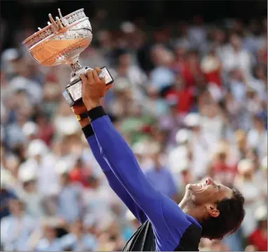  ?? The Associated Press ?? Spain's Rafael Nadal lifts the cup after defeating Switzerlan­d's Stan Wawrinka in their final match of the French Open tennis tournament at the Roland Garros stadium on Sunday in Paris. Nadal has won his record 10th French Open title, beating No. 3...