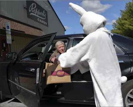  ?? BILL UHRICH — MEDIANEWS GROUP ?? The Easter Bunny, played by Ashley Reinstein, 20, of Oley, hands customer Jon Leight of Lansdale, Montgomery County, a curbside delivery of Easter candy at Reppert’s Candy in Oley Township Thursday as a way to help customers during the coronoviru­s pandemic.